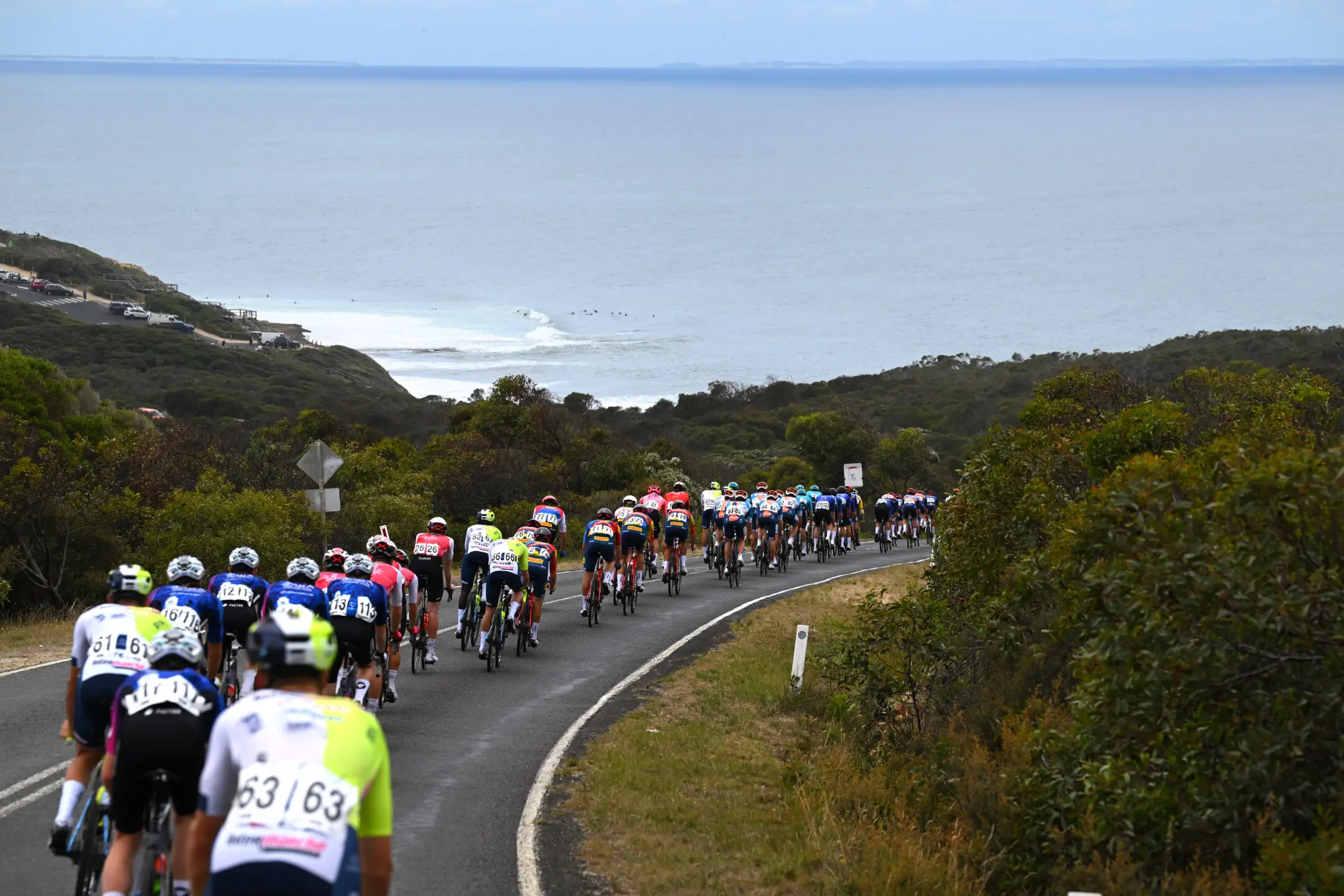 A general view of the peloton competing close to the Bells beach during the 8th Cadel Evans Great Ocean Road Race 2024